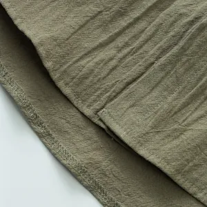 Dettaglio ravvicinato del tessuto in lino di qualità e delle cuciture di una camicia estiva da uomo.