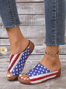 Close-up of women's wedge sandals with a vibrant American flag stars and stripes pattern.