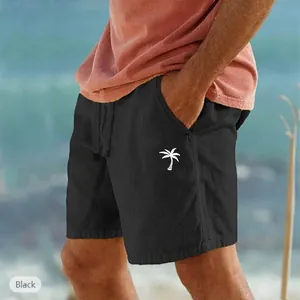 Dettaglio pantaloncini mare neri cotone lino con stampa palma bianca e cordoncino in vita.