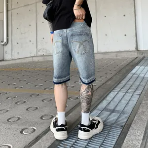 Pantaloncini di jeans uomo larghi con strass e orlo sfrangiato in lavaggio blu chiaro