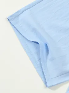 Close-up showing the breathable light blue cotton linen fabric and hem stitching on men's shorts