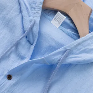 Dettaglio di una camicia con cappuccio senza maniche in lino azzurro da uomo con etichetta.