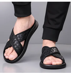 Detail view of stylish men's black woven cross-strap slide sandals for beach use
