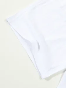 Close-up of white cotton linen men's shorts showing fabric texture and hem detail.