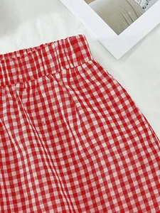 Gros plan détaillé d'un short vichy rouge et blanc avec une taille élastiquée