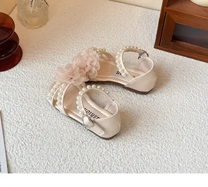 Detailopname van stijlvolle prinsessensandalen voor peutermeisjes met parels en bloemen.