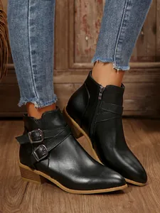 Close-up of black pointed toe ankle boots with buckle straps and chunky heels