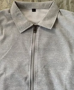 Détail de la veste grise en maille gaufrée avec fermeture éclair et col polo taille S.