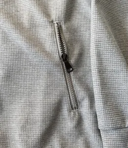 Gros plan sur la fermeture éclair durable et la texture en maille gaufrée d'une veste homme