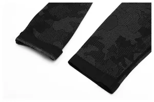 Close-up of seamless jacquard knit cuffs on a black athletic performance long sleeve shirt.