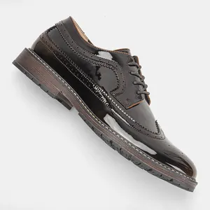 Vista dettagliata delle scarpe brogue da uomo in pelle verniciata lucida con decorazioni
