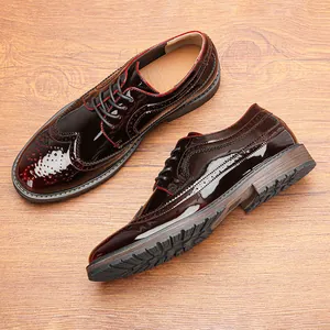 Vista dettagliata delle scarpe brogue in pelle verniciata bordeaux lucido da uomo.