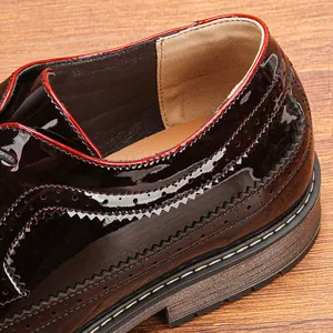 Dettaglio delle cuciture brogue e della pelle verniciata su scarpe eleganti bordeaux