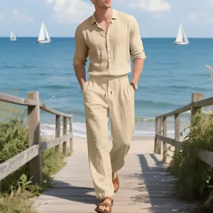 Modello che cammina sulla spiaggia indossando set beige in lino camicia e pantaloni