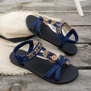 Blaue flache Sandalen im Ethno-Stil mit dekorativen Holzblumen auf Holzuntergrund