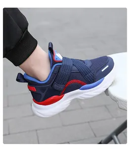 Detalle de una zapatilla deportiva para niño en malla azul transpirable con detalles rojos