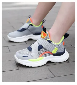 Primer plano de zapatillas de malla ligera para niños con cierre de velcro en suelo gris