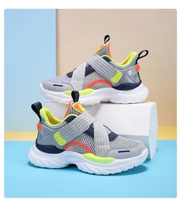 Detalle de zapatillas infantiles de malla gris con detalles neón y cierre de velcro