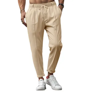 Detail view of khaki slim-fit drawstring trousers for men, business casual style.
