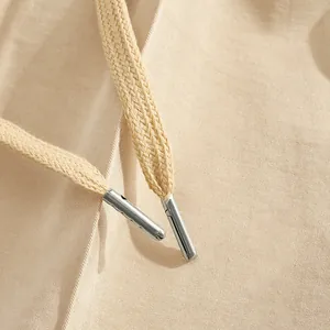 Close-up detail of drawstring with metal tips on beige casual men's pants