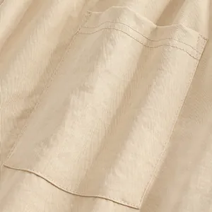 Detailed macro view of a classic patch pocket on beige men's casual pants with fine stitching
