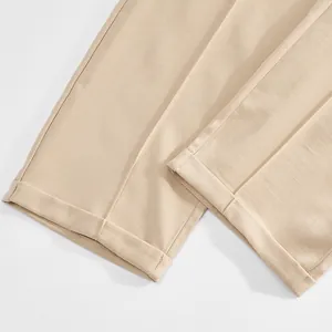 Close-up detail of beige men's business casual trousers featuring a stylish cuffed hem