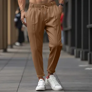 Detailed view of men's slim-fit brown casual trousers featuring a drawstring waist design