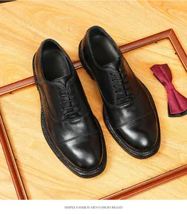 Vue détaillée de chaussures Oxford en cuir noir faites à la main sur fond de bois