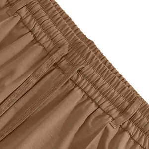 Close-up detail of brown men's casual pants featuring elastic waistband and drawstring