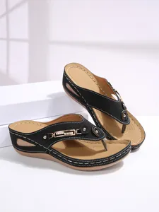 Detailed view of women's black wedge thong sandals featuring gold chain and rhinestones