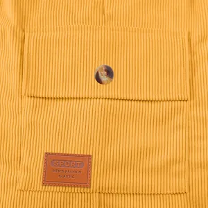 Gros plan sur le velours côtelé jaune d'un short pour homme avec poche et écusson