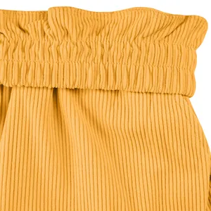Détail du tissu en velours côtelé jaune et de la taille élastiquée d'un short décontracté