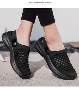 Close-up side view of black breathable fly-knit mesh sandals worn by a model outdoors.