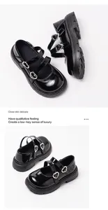 Close-up of girls' black patent leather Mary Jane shoes with silver heart buckles.