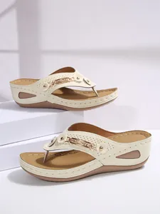 Elegant beige wedge flip-flops for women featuring a stylish rhinestone metal chain detail