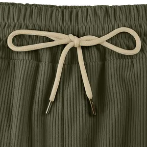 Gros plan sur le cordon de serrage beige et le tissu texturé olive d'un short décontracté