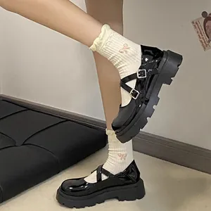 Girls' black patent leather Mary Jane shoes with platform sole and cross straps.