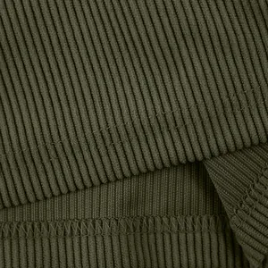 Gros plan sur la texture du tricot côtelé vert olive et les détails de couture