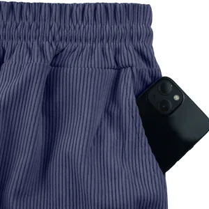 Détail montrant la texture du velours côtelé et la poche profonde du short bleu