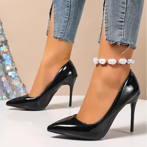 Vue latérale d'escarpins élégants en cuir verni noir à bout pointu portés avec un jean