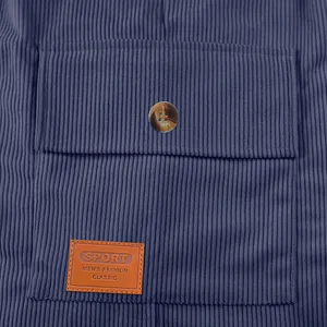 Gros plan sur la poche d'un short en velours côtelé bleu avec un écusson de mode