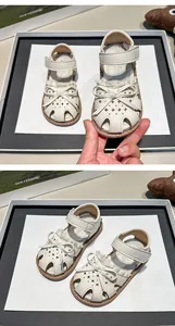 Detail view of off-white toddler girl sandals with cute bow and closed-toe design