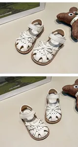Detailed view of white girls' sandals featuring a delicate bow and lace trim