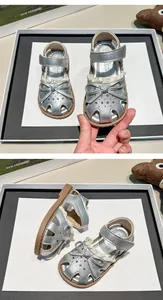 Detailed view of silver girls' princess sandals with a bow and soft non-slip sole