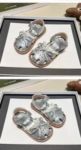 Macro view of silver girls' princess sandals featuring a bow and star-shaped cutouts