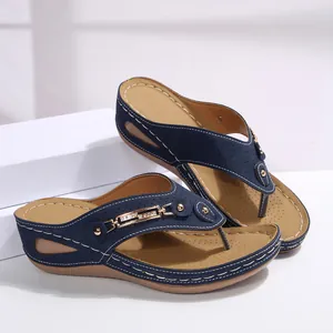 Elegantes sandalias de cuña azul marino con cadena dorada y detalles de pedrería