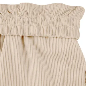 Détail rapproché de la taille élastique paperbag sur un short en velours côtelé beige.