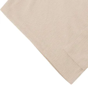 Gros plan sur la texture du tissu en maille côtelée beige d'un short décontracté.