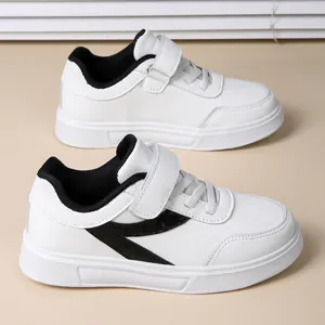 Casual white sneakers for girls featuring black accents and a practical Velcro strap closure