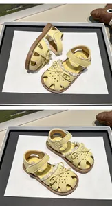 Macro view of yellow girls' summer sandals with cute bow-knot and lace trim detail
